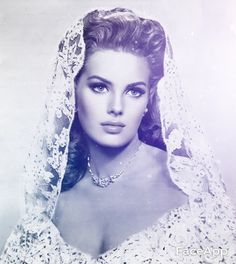 an old black and white photo of a woman wearing a wedding dress with a veil over her head