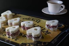 small pastries sitting on top of a tray next to a cup of coffee