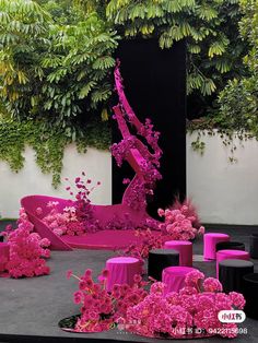 an artistic display with pink flowers and chairs