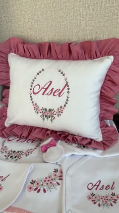 a bed topped with pillows and blankets covered in pink ruffles