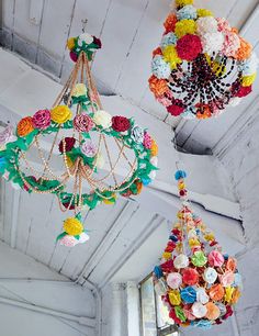 three colorful chandeliers hanging from the ceiling in a room with white walls and ceilings