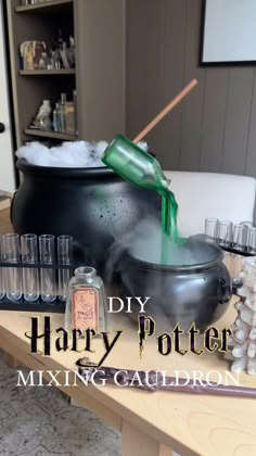 a harry potter mixing caulder is being filled with liquid and flasks