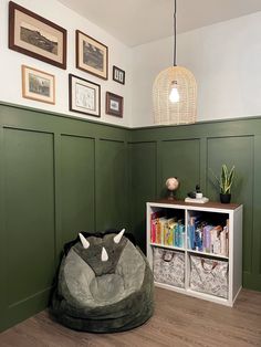 a room with green paneling and an animal shaped bean bag chair in the corner