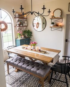 a dining room table and bench with candles on it