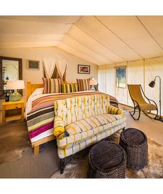 a bed sitting inside of a tent next to a fire place