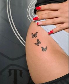 a woman's stomach with three butterflies on her side and the word love written in black ink