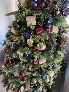 a christmas tree decorated with ornaments and ribbons