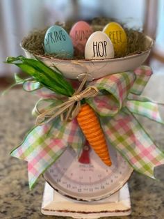 some eggs are in a bowl on top of a scale with a carrot tied to it