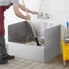 a man is cleaning the floor with a mop and bucket in front of him