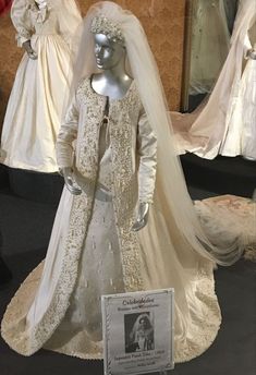 a wedding gown and veil on display in a museum