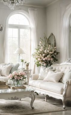 a living room filled with white furniture and flowers