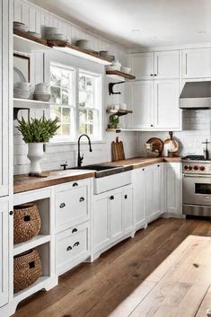 a kitchen with white cabinets and wood flooring is pictured in this image, there are baskets on the counter next to the sink