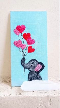 an elephant is holding some red and pink heart balloons on a blue background with a white paper towel