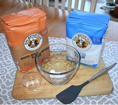 ingredients to make coffee sit on a wooden cutting board next to a bag of coffee