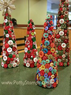 three small christmas trees made out of buttons and other things are sitting on the table