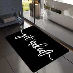 a black bathroom rug with the word dream written in cursive font on it