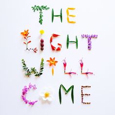 the words'the light is come'are made out of flowers and leaves on a white background