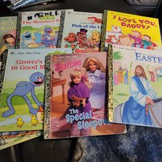 several children's books sitting on top of a couch