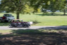 an old race car driving down the road