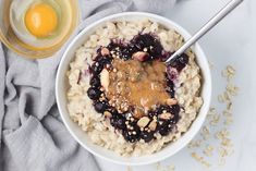 a bowl of oatmeal topped with fruit and nuts next to a glass of orange juice