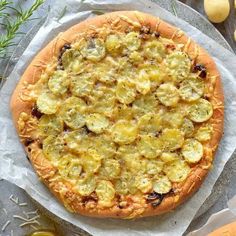 a pizza sitting on top of a table covered in cheese and veggie toppings