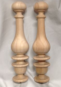 two wooden candlesticks sitting next to each other on a white sheeted surface