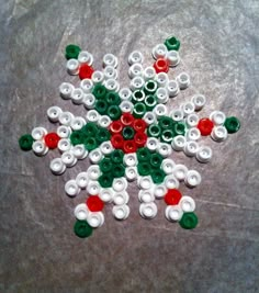 a snowflake made out of plastic buttons on a counter top with the colors red, white and green