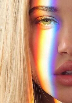 a woman with long blonde hair and rainbow makeup