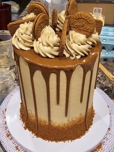 there is a large cake with chocolate icing and cookies on the top that are drizzled