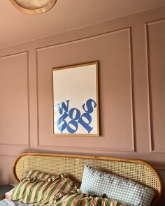 a bedroom with pink walls and a wicker bed