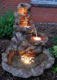 an outdoor fountain with lights on it