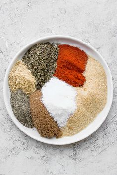 a white bowl filled with different types of spices