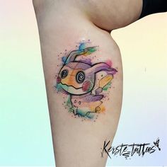 a colorful tattoo on the side of a woman's thigh with an image of a fish