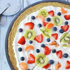 a pie topped with fresh fruit and whipped cream