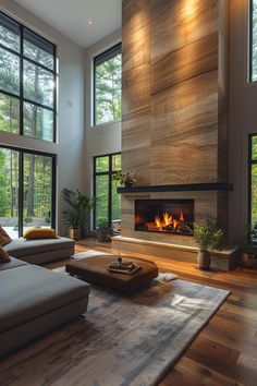 a living room with large windows and a fire place in the center, surrounded by wood flooring