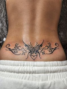 a woman's back with a butterfly tattoo on her lower side ribcage