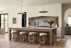 a kitchen island with stools in front of it