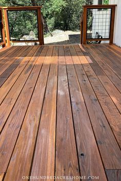 a wooden deck with railings leading to trees