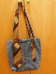 a denim purse with a tie hanging from it