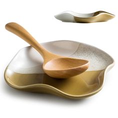 two wooden spoons sitting on top of a white plate next to a silver spoon