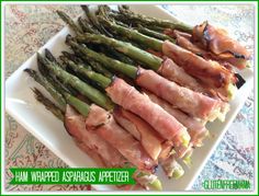 asparagus and ham wrapped in bacon on a white plate with the words ham wrapped asparagus after