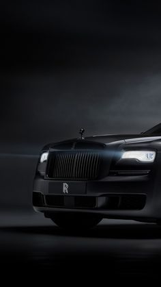 a black rolls royce parked in the dark