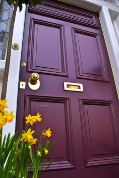 a purple door with yellow flowers in front of it