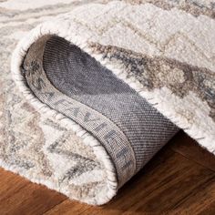 a close up view of a rug on the floor with wood floors in the background