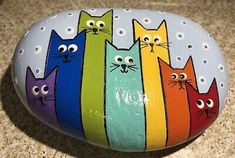 a painted rock with five cats on it