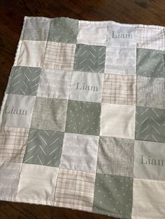 a close up of a quilt on a wooden floor with the words i am, lain, and lama