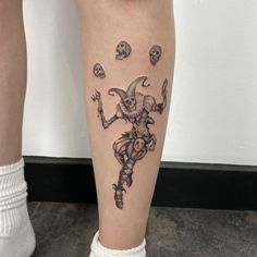 a tattoo on the leg of a person with skulls around them and a skull in the background