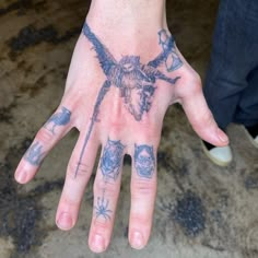 a person's hand with tattoos on it