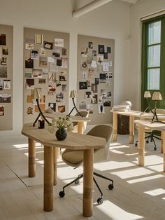 a room with several tables and chairs in it, all covered by pictures on the wall