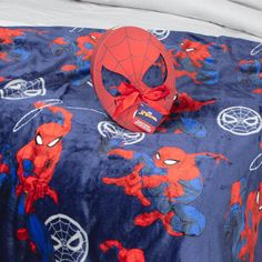 a spiderman bed spread with a red bow on it